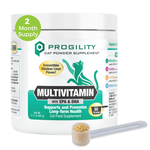 A white tub of Progility Cat Powder Supplement Multivitamin with a green and black label, shown on a white background with a small clear scoop containing tan powder in front and a green circular '2 Month Supply' badge on the upper left.